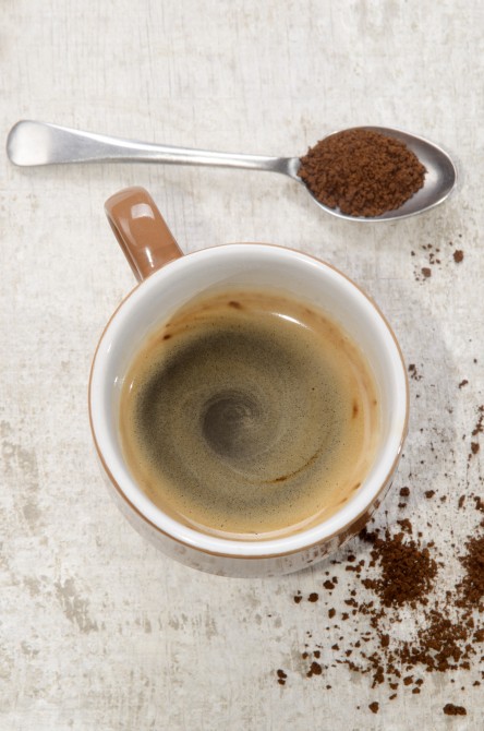 freshly brewed instant coffee in a cup, some powder on spoon and wood freshly brewed instant coffee in a cup, some powder on spoon and wood
