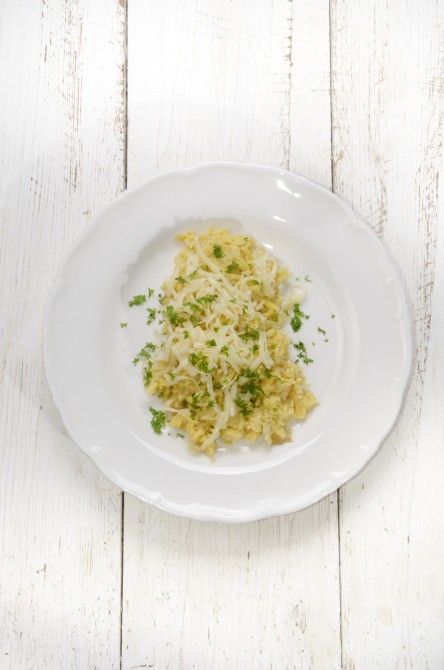 spaetzle with parsley, onion and melted cheese on a white plate spaetzle with parsley, onion and melted cheese on a white plate