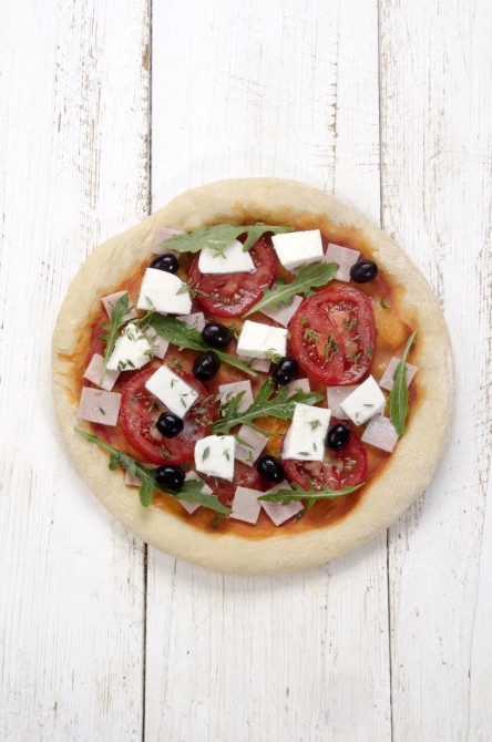pizza with ham, mozzarella, tomato, rucola, black olive and thyme