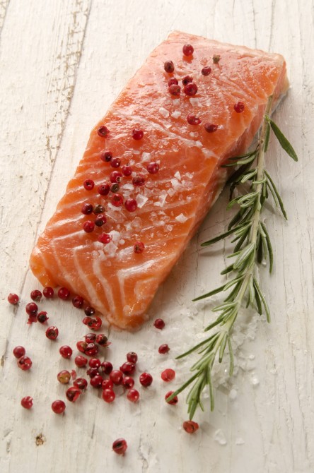 raw salmon fillet with coarse salt, red pepper and rosemary on rustic wooden table raw salmon fillet with coarse salt, red pepper and rosemary on rustic wooden table