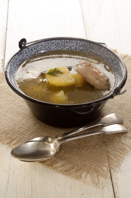 cooked potato soup with chicken meat and parsley in a small kettle