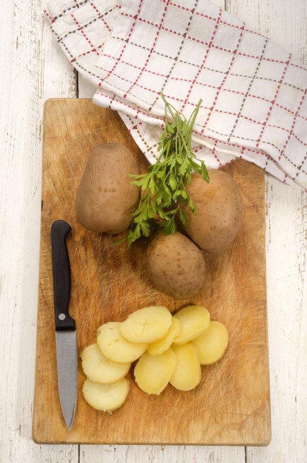 boiled potato on a wooden board are prepared as fried potatoes