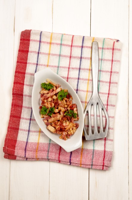 fried bacon bits with parsley in a white bowl