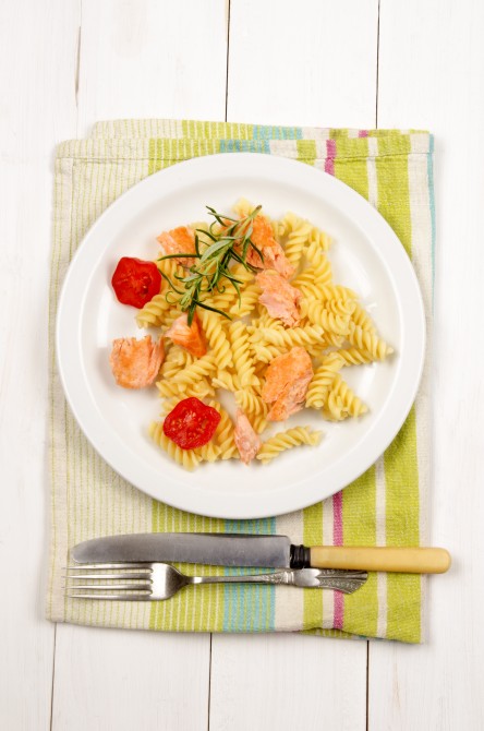 noodles with grilled wild salmon, tomatoes and rosemary on a plate noodles with grilled wild salmon, tomatoes and rosemary on a plate