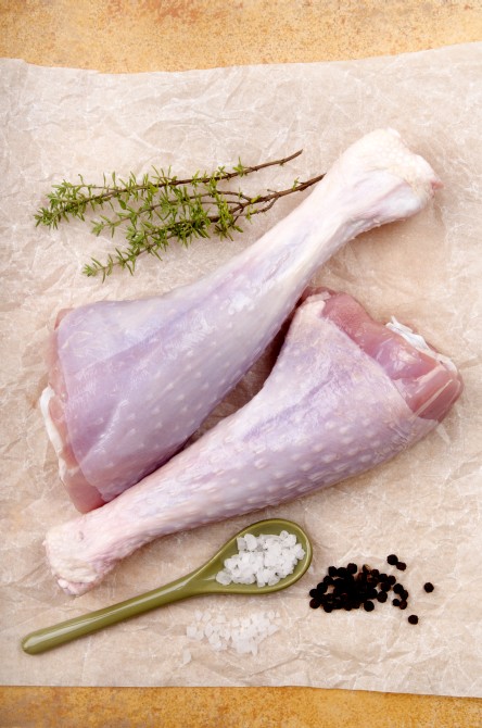 raw turkey drumsticks with thyme, pepper and coarse salt on white kitchen paper raw turkey drumsticks with thyme, pepper and coarse salt on white kitchen paper