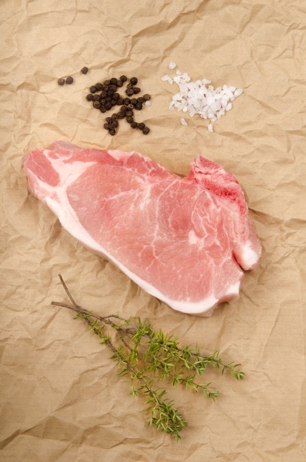 raw pork bone in loin chop with coarse salt, pepper and thyme