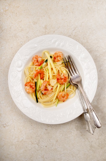 spaghetti with courgette strips, gartlic and prawns on a plate