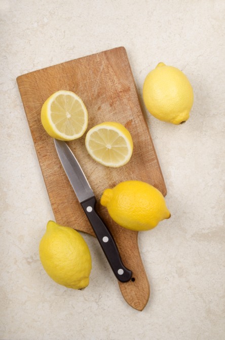 fresh lemon and kitchen knife on a wooden board fresh lemon and kitchen knife on a wooden board
