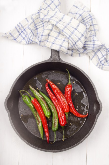 grilled green and red chili in a cast iron pan grilled green and red chili in a cast iron pan