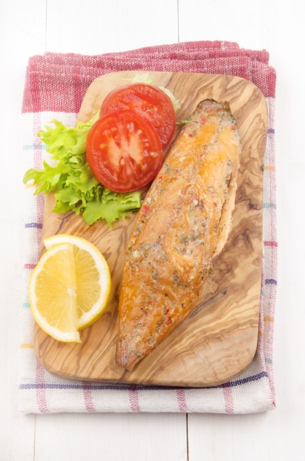 smoked mackerel with salad, tomato and lemon on a wooden board smoked mackerel with salad, tomato and lemon on a wooden board