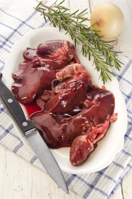 fresh chicken hearts and chicken livers with rosemary on a plate