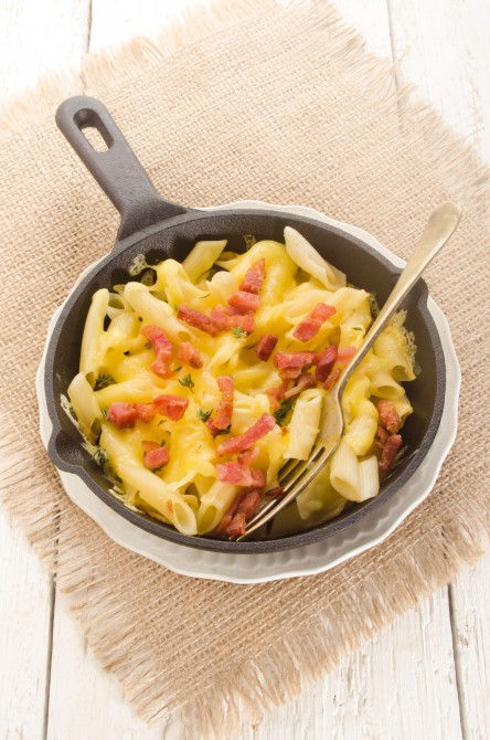 pasta with grilled bacon, thyme and melted cheese in a cast iron pan pasta with grilled bacon, thyme and melted cheese in a cast iron pan