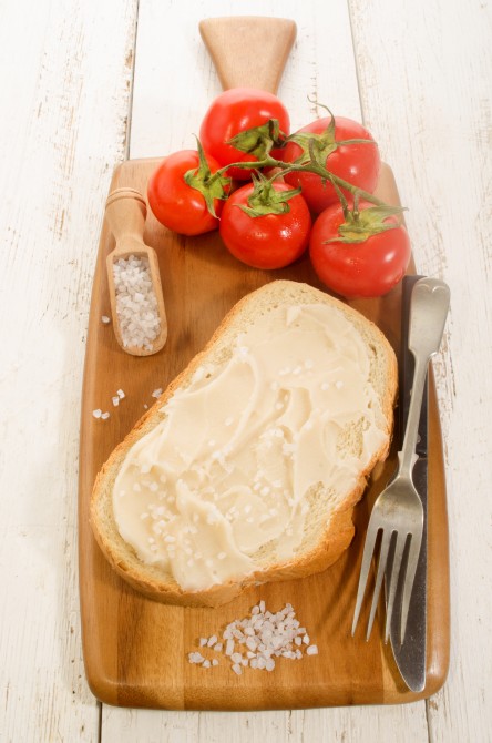 lard bread with coarse salt and tomatoes on wooden board