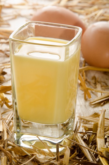 home made egg liqueur, shot glass and fresh eggs in the straw