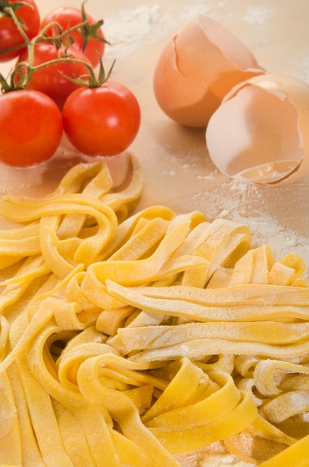 home made tagliatelle, tomato and egg on wooden board home made tagliatelle, tomato and egg on wooden board