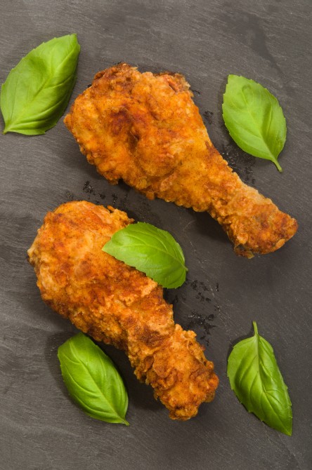 roasted chicken drumstick with basil on slate