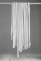 homemade tagliatelle on a wooden stick to dry