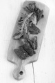 sun dried tomatoes with rosemary on a wooden board
