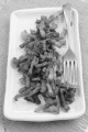 grilled bacon bits on a plate with parsley and fork