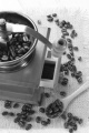 used coffee grinder and beans on a wooden spoon