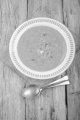 warm pumpkin potato soup and spoon on wood