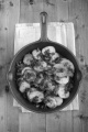 fried organic potatoes with bacon and parsley in a cast iron pan