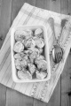 cooked baby potato with creme fraiche and chives in a white bowl