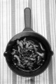 cast iron pan with grilled bacon on a kitchen towel
