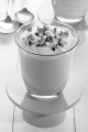vanilla dessert in a glass with chocolate flakes and spoon in the background