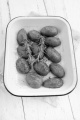 baked potato with rosemary and spice in a enamel bowl