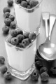 organic yogurt and blueberries in a square shot glass and spoon on wooden table