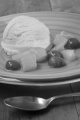 vanilla yogurt ice cream with fruit cocktail and sweet sauce on a blue plate