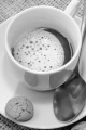 cup with coffee, milk foam and biscuit