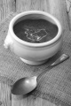 beetroot soup with cream and thyme in a white bowl on jute