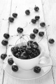 sweet cherries in a cup and on wooden table