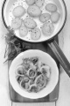 fried bacon and onion ring in a bowl, pan with sliced potato and parsley