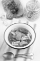 mediterranean fish soup with tomato, red bell pepper, noodle and garlic in a bowl