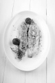 grilled mackerel with thyme and tomato on a white plate