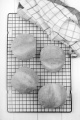 four bread rolls on a cooling rack with kitchen towel