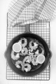 grilled king prawns with lemon slice and crushed garlic in a cast iron pan