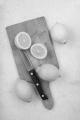 fresh lemon and kitchen knife on a wooden board