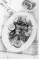 grilled hungarian pork, red pepper, onion and courgette skewers on an white oval plate