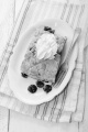 cherry crumble with whipped cream and fork on oval plate
