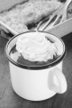 hot chocolate with whipped cream in a white and blue enamel mug